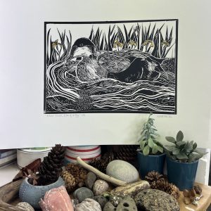 eider duck linoprint in black and white on water with yellow irises in background
